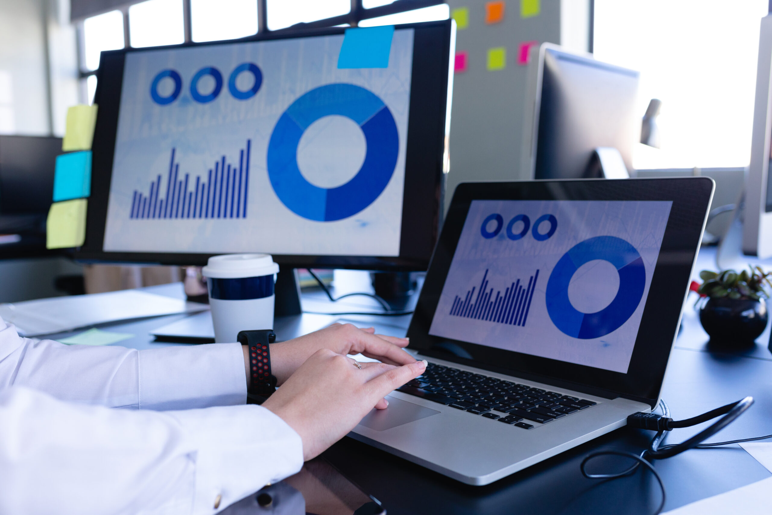 Side view mid section of a Caucasian woman working in the modern office, sitting by a desk and using a desktop computer. Social distancing and self isolation in quarantine lockdown