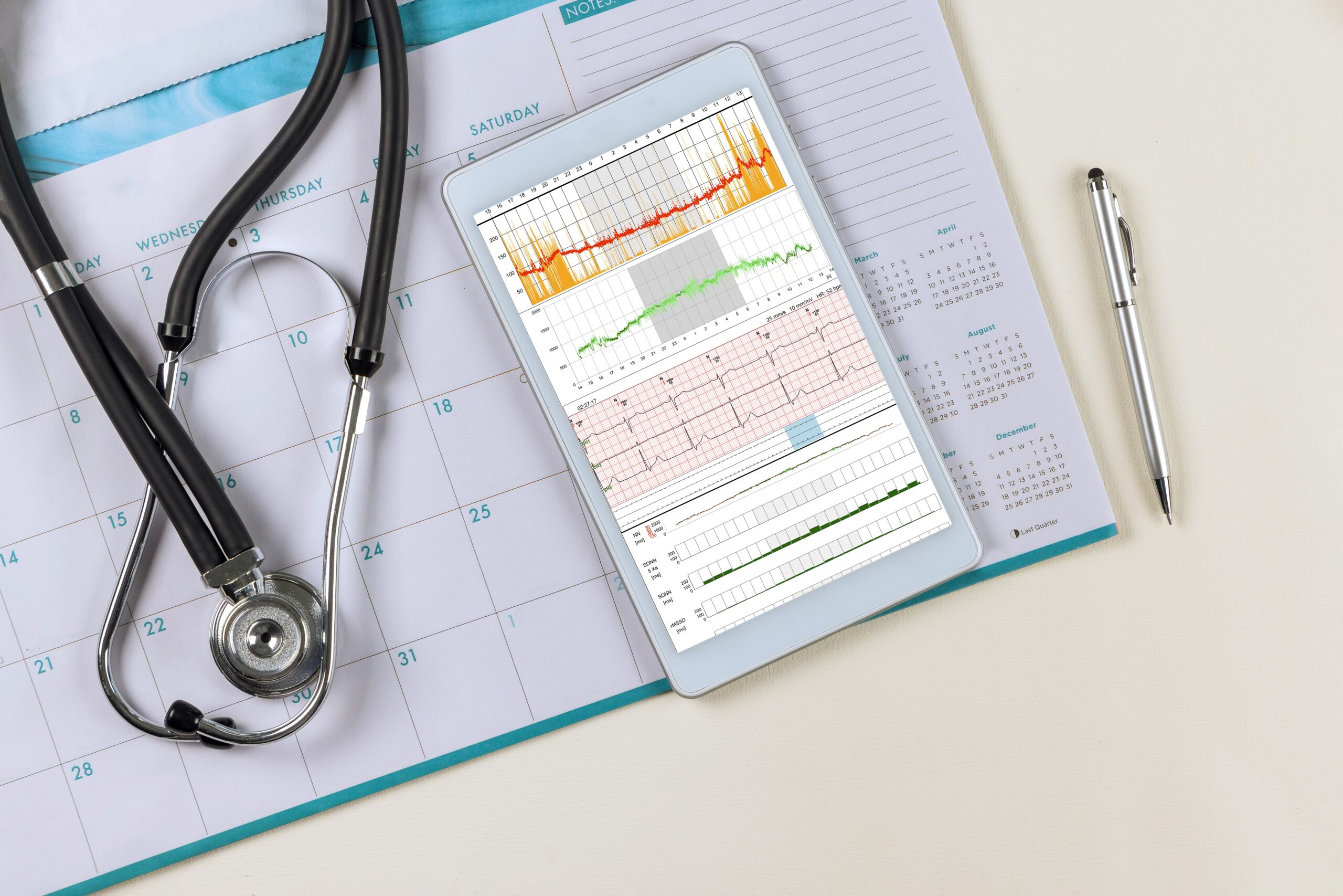 Medical worktable doctor desk with heart cardiogram of wave on cardiography heart report analysis the patient in digital tablet