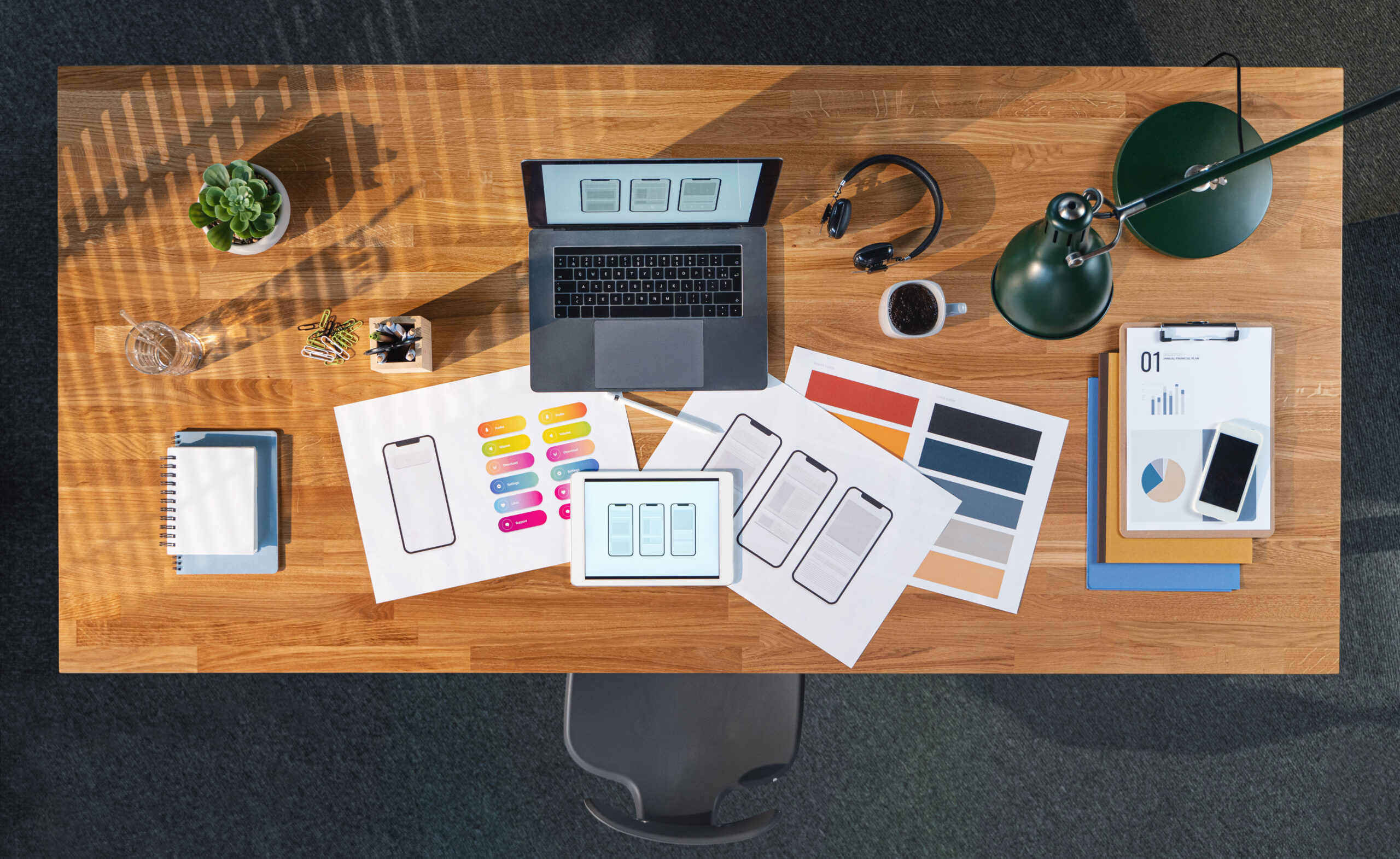 Top view of desk with computer, tablet and paperwork in home office. Creative business concept.
